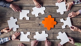 People putting together pieces of a puzzle